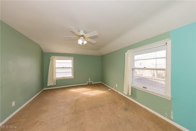 unfurnished room featuring vaulted ceiling, a ceiling fan, baseboards, and carpet floors