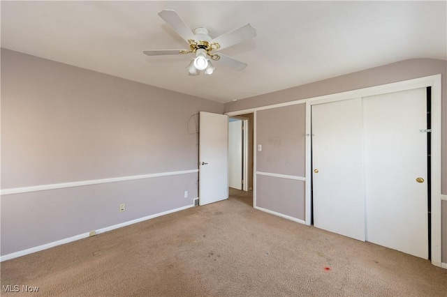 unfurnished bedroom featuring a closet, carpet floors, baseboards, and ceiling fan