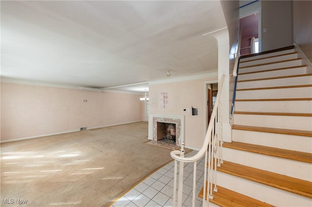 interior space with tile patterned floors, visible vents, ornamental molding, carpet flooring, and a premium fireplace