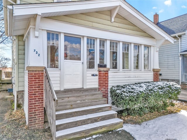 doorway to property featuring brick siding