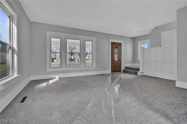 foyer with baseboards, visible vents, and carpet floors