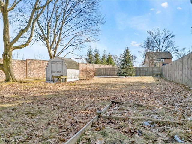 view of yard with a fenced backyard, an outdoor structure, and a shed