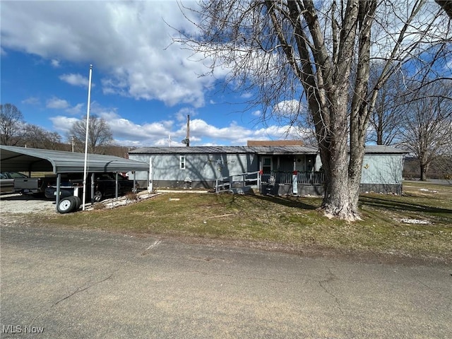 manufactured / mobile home featuring a detached carport and a front lawn