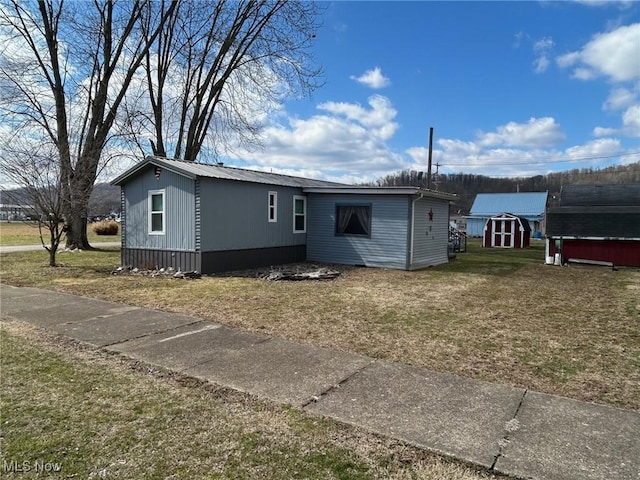 exterior space featuring an outbuilding, a storage shed, and a yard