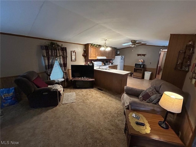 living room with lofted ceiling, light colored carpet, ceiling fan, and ornamental molding