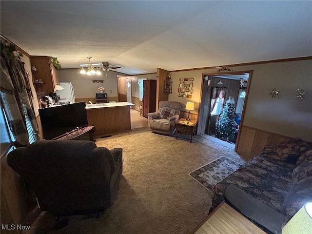 living room with lofted ceiling, crown molding, light colored carpet, and a wainscoted wall