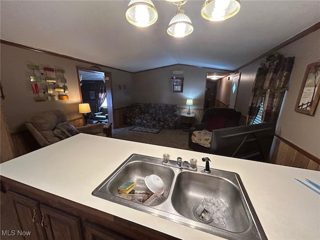 kitchen with a sink, open floor plan, light countertops, and vaulted ceiling