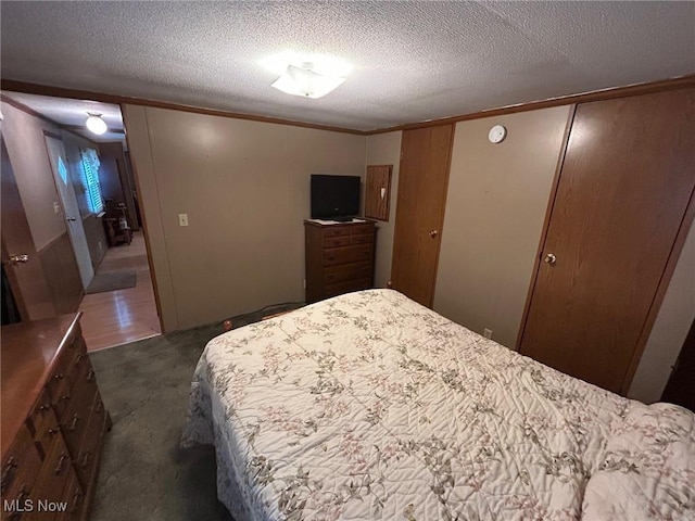 carpeted bedroom with crown molding and a textured ceiling