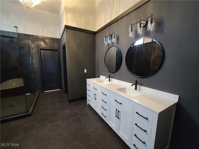 bathroom with tile patterned flooring, a shower stall, double vanity, and a sink