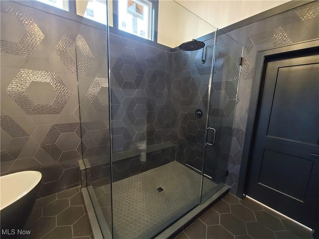 bathroom with tile patterned flooring, a stall shower, and a freestanding bath