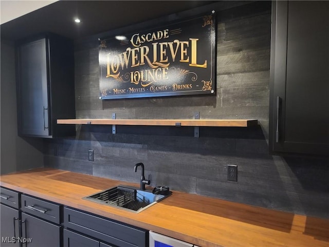 bar with a sink, wet bar, and tasteful backsplash