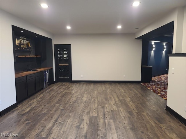 bar with a sink, wet bar, wood finished floors, and recessed lighting