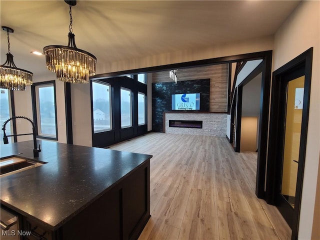 interior space with light wood finished floors, a chandelier, and a sink