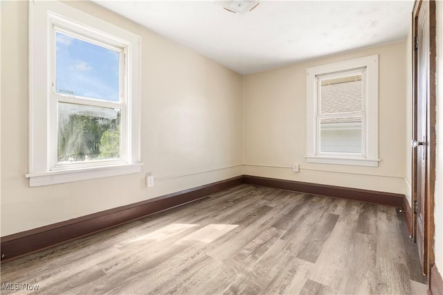 spare room with wood finished floors and baseboards