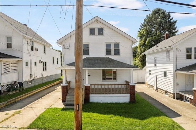 traditional style home featuring covered porch, a front yard, and a shingled roof