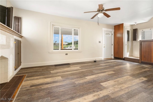 unfurnished living room with baseboards, wood finished floors, and a ceiling fan