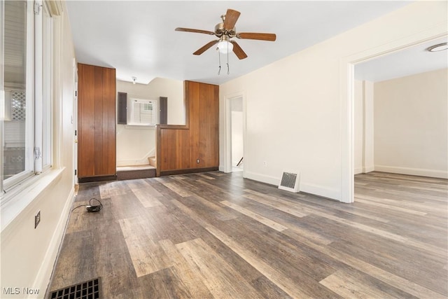 spare room featuring a ceiling fan, wood finished floors, visible vents, and baseboards