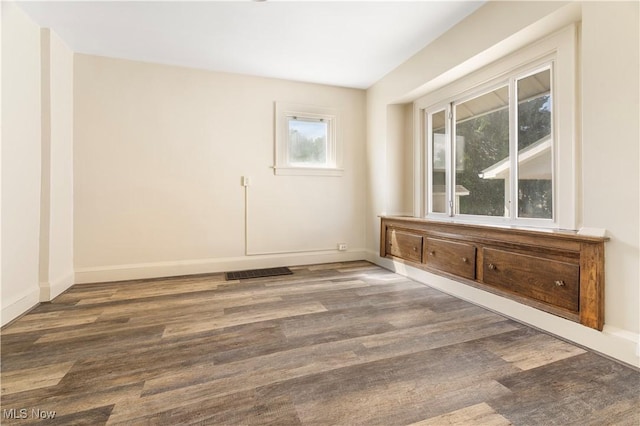 spare room with visible vents, baseboards, and wood finished floors