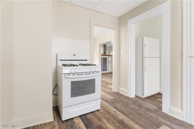 kitchen featuring dark wood finished floors, white appliances, and a paneled ceiling