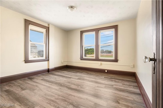 unfurnished room featuring baseboards and wood finished floors