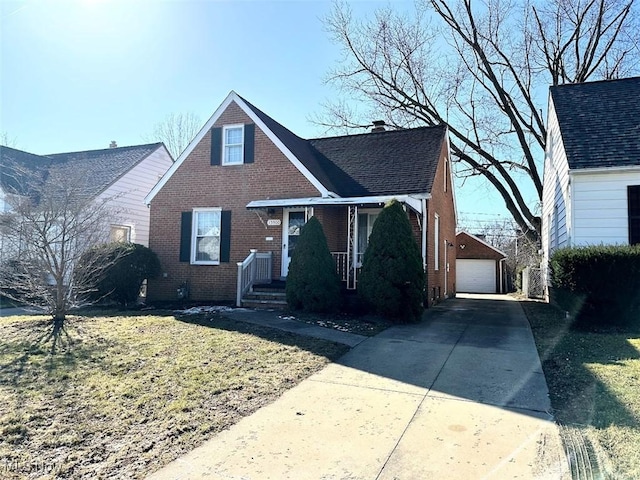 view of front of house featuring brick siding, a shingled roof, a chimney, a garage, and an outdoor structure