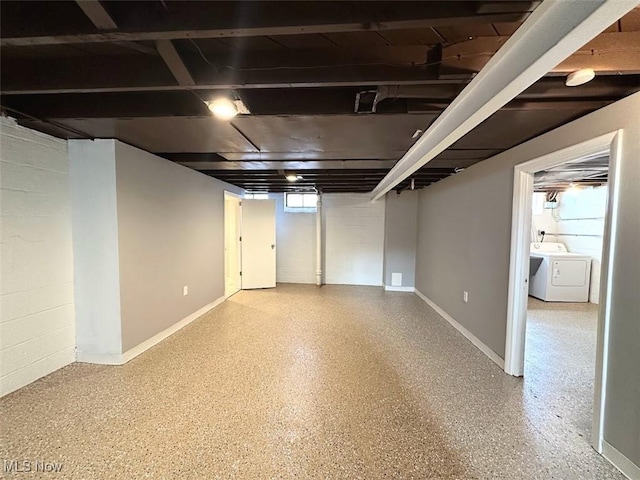 basement featuring washer and dryer, baseboards, and concrete block wall