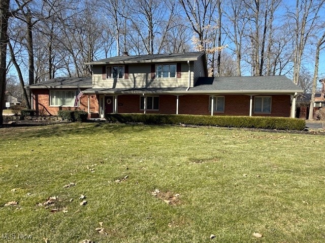 traditional-style home featuring a front yard and brick siding