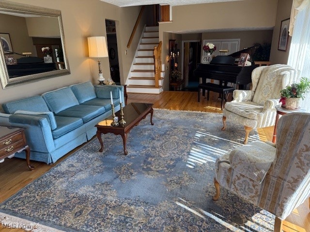 living area featuring stairs and wood finished floors