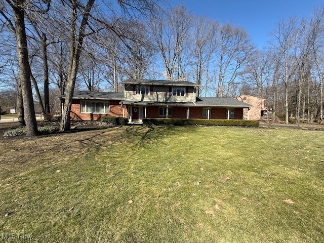 view of front of home with brick siding and a front lawn