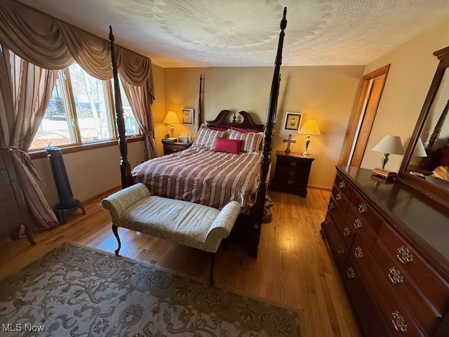 bedroom featuring light wood-style flooring and a textured ceiling