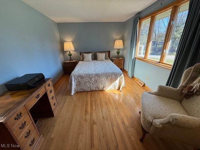 bedroom featuring visible vents and light wood-style floors