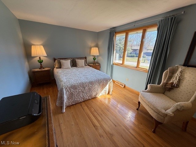 bedroom with wood finished floors and visible vents