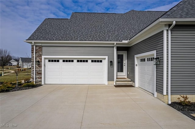 view of front of house featuring a garage, stone siding, roof with shingles, and driveway