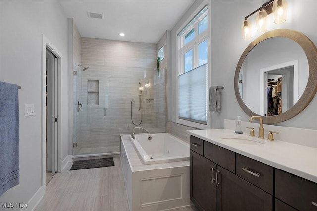 bathroom featuring visible vents, a shower stall, vanity, and a tub with jets