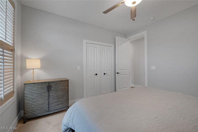 bedroom featuring a closet, baseboards, carpet, and a ceiling fan