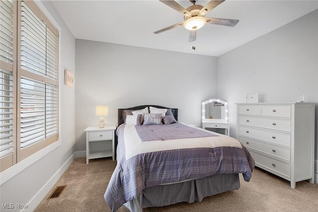 bedroom featuring light carpet, visible vents, a ceiling fan, and baseboards