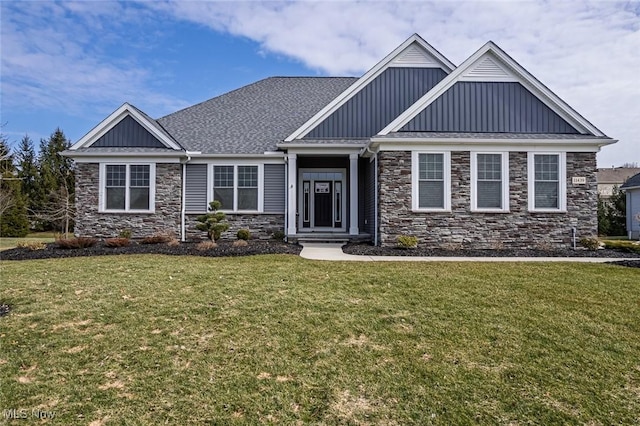 craftsman-style home with board and batten siding, a shingled roof, and a front lawn