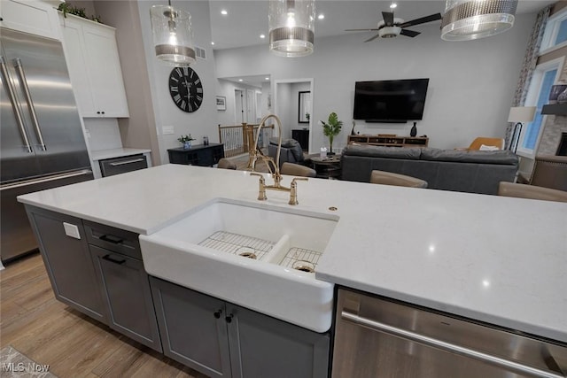 kitchen with light countertops, light wood finished floors, open floor plan, and appliances with stainless steel finishes