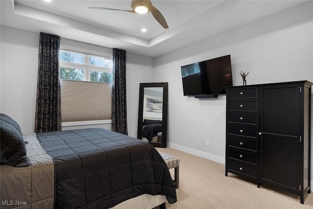 bedroom with baseboards, ceiling fan, light colored carpet, recessed lighting, and a raised ceiling