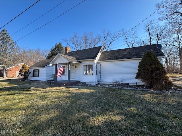 view of front facade featuring a chimney, a front lawn, and a shingled roof