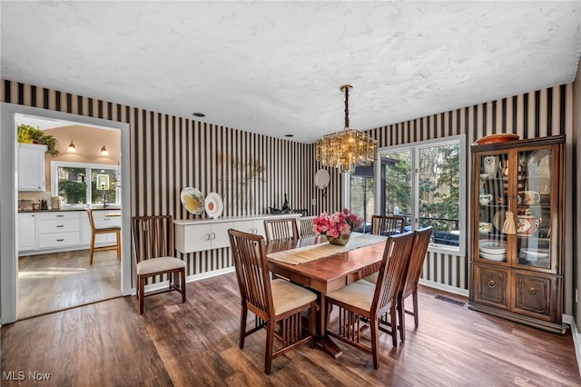 dining space featuring visible vents, plenty of natural light, wallpapered walls, and dark wood-style flooring