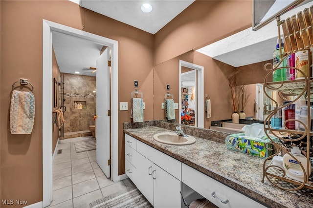 full bathroom featuring vanity, a shower stall, baseboards, and tile patterned flooring