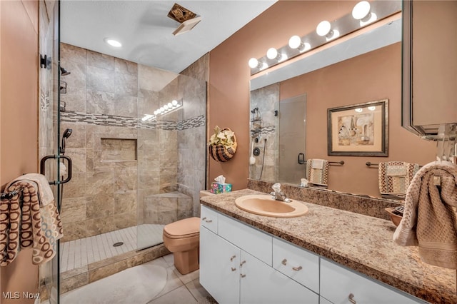 bathroom featuring vanity, toilet, a stall shower, and tile patterned flooring