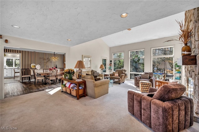 carpeted living area with a stone fireplace, recessed lighting, a textured ceiling, and lofted ceiling