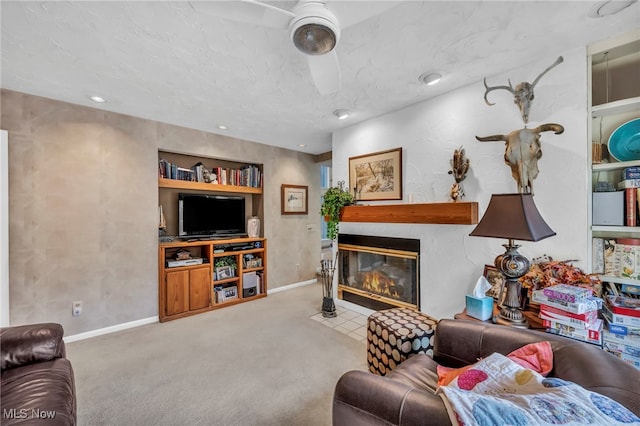 carpeted living area with built in shelves, baseboards, and a fireplace with flush hearth