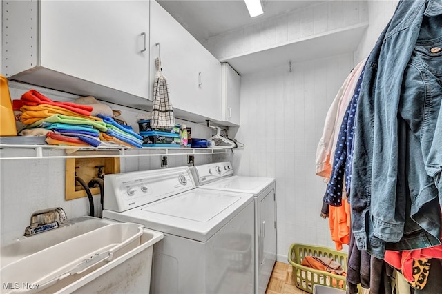 washroom featuring washer and dryer, cabinet space, and a sink