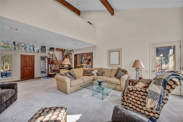 living area featuring stairway, beam ceiling, carpet, and a towering ceiling