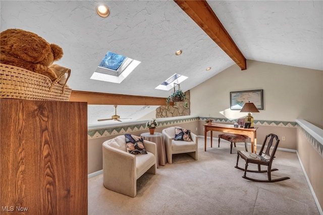 living area with vaulted ceiling with skylight, a textured ceiling, baseboards, and carpet floors