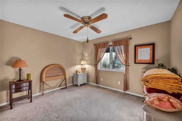 living area featuring a ceiling fan, baseboards, and carpet floors