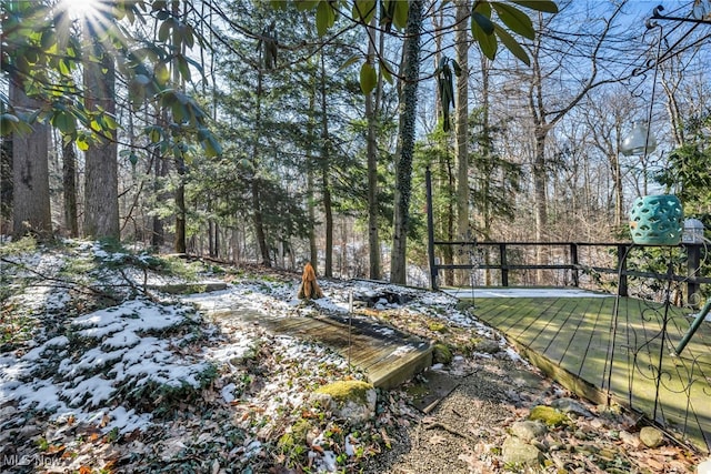 view of yard featuring a view of trees and a deck